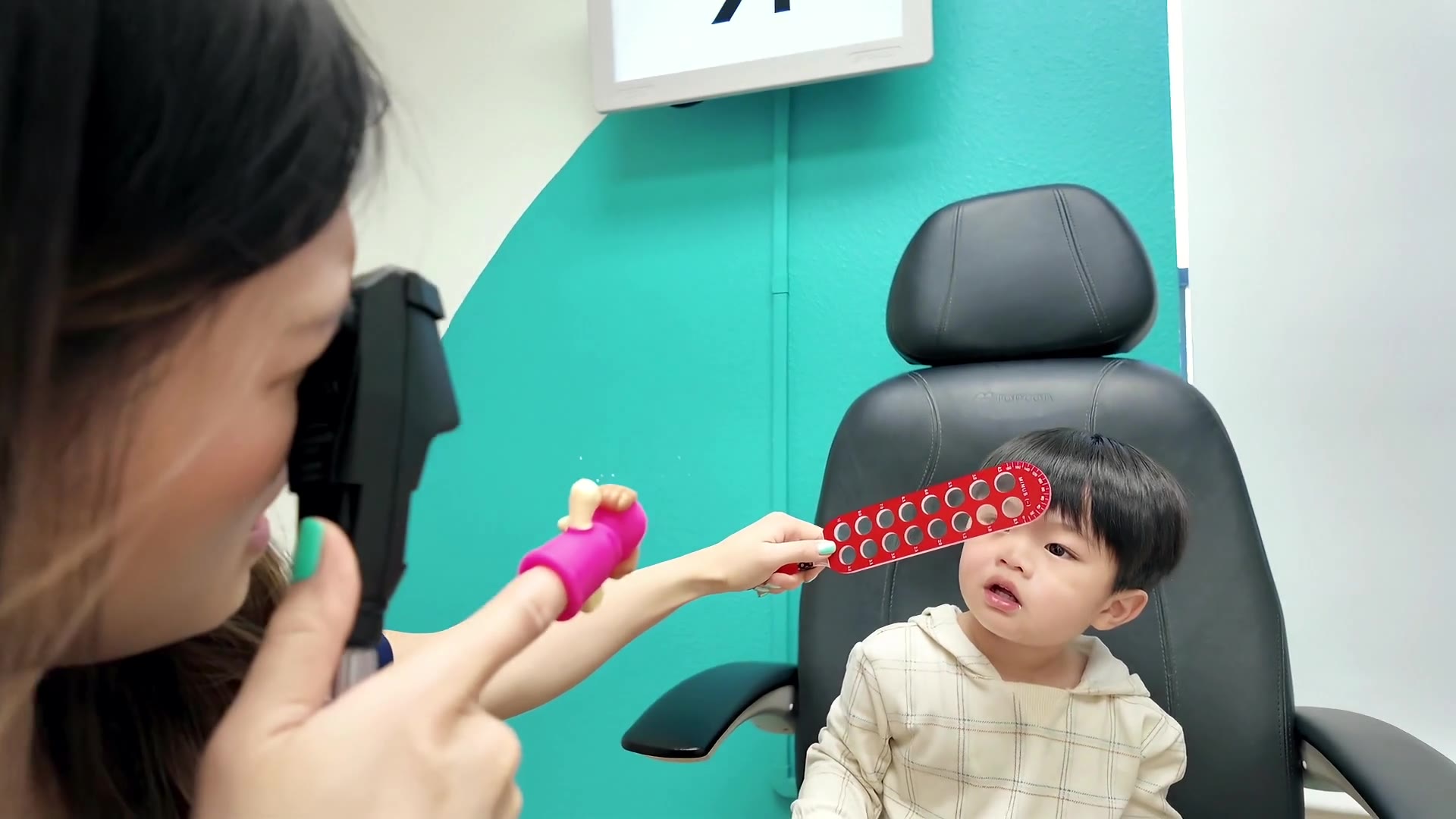 Dr. Tran making a young child smile during an eye exam